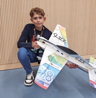 Joshua DeBernardi, Juniorpilot F3P-AFM, holding a large model airplane.